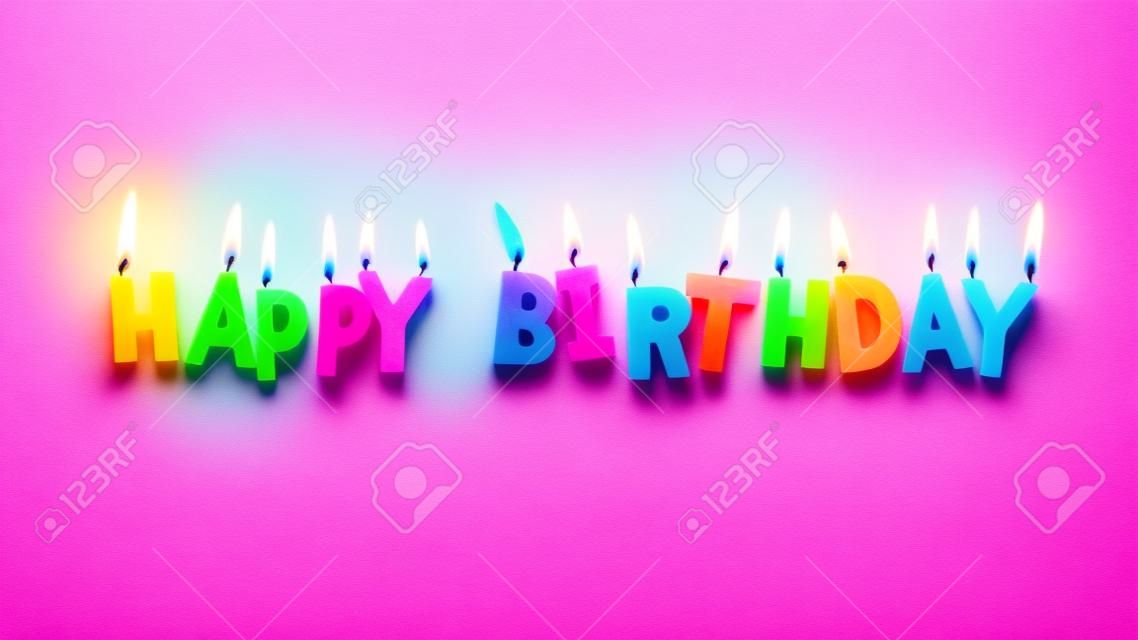 Happy birthday colorful candles on pink paper background
