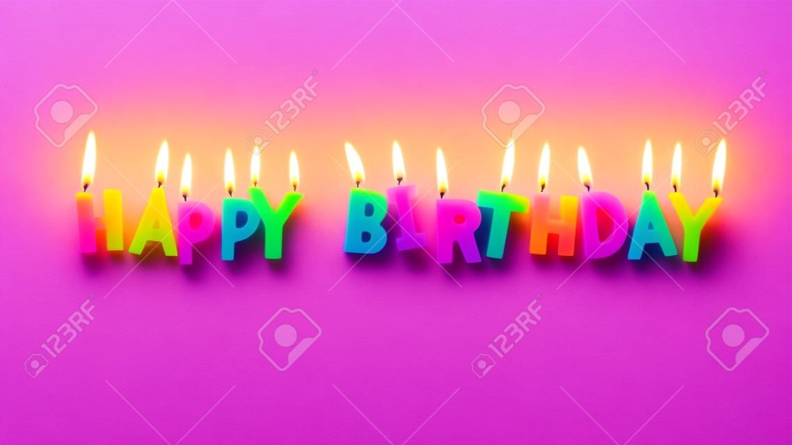 Happy birthday colorful candles on pink paper background