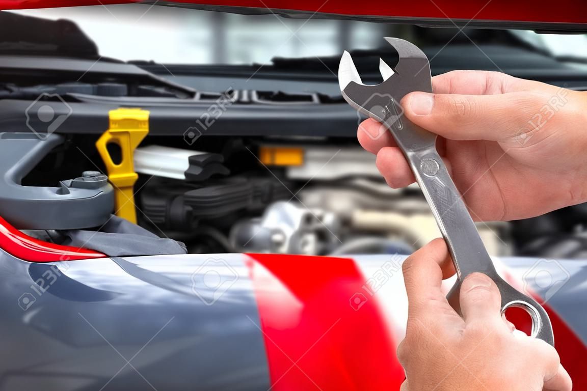 Main de mécanicien automobile avec clé à main. Garage auto réparation.