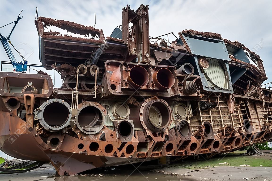 Riesige rostige Teile eines außer Dienst gestellten Seeschiffs, die zerschnitten und am Ufer gelassen wurden.
