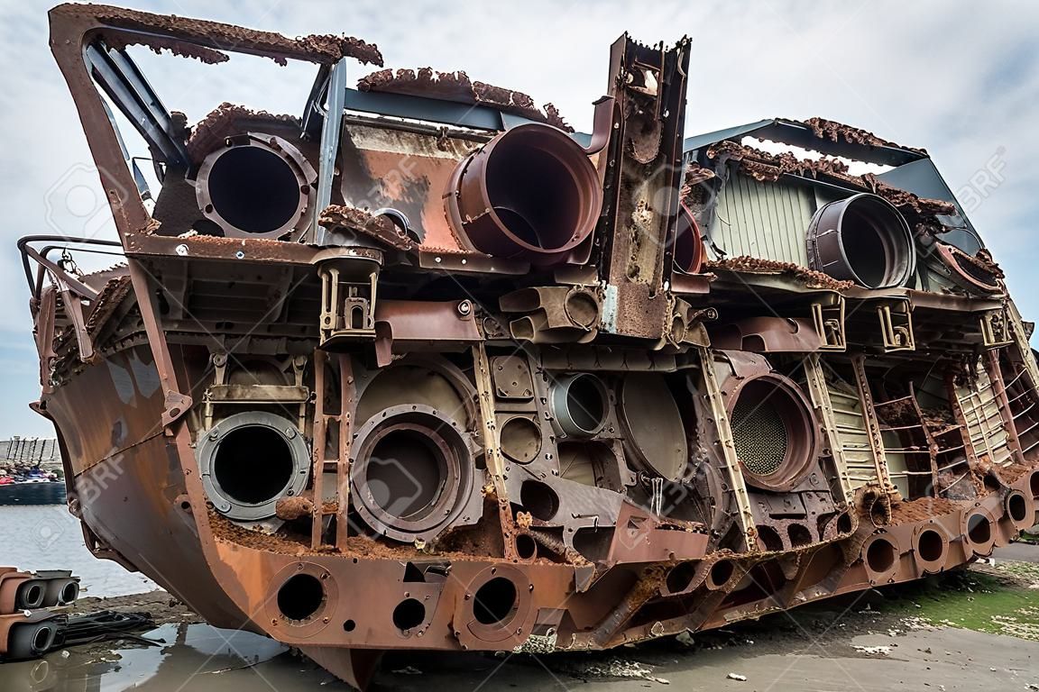 Huge rusty pieces of decommissioned marine ship that was cut and left on the shore.