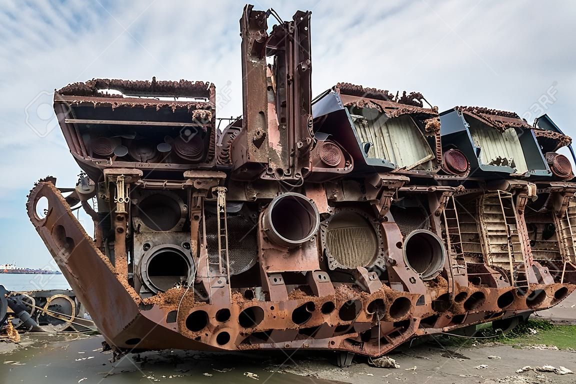 Enormes piezas oxidadas de un barco marino desmantelado que fue cortado y dejado en la orilla.