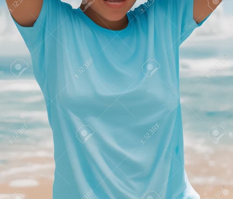 La chica de la playa con una camiseta mojada.