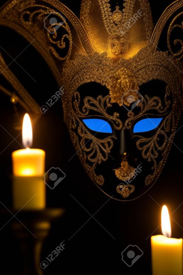 Encender velas contra bella máscara veneciana clásica sobre fondo oscuro