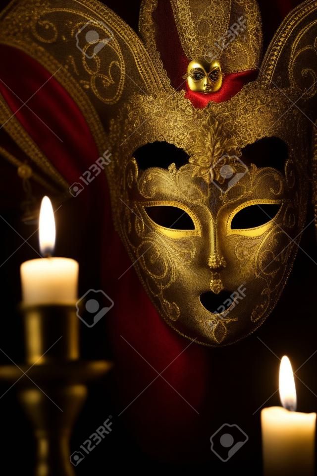 Encender velas contra bella máscara veneciana clásica sobre fondo oscuro