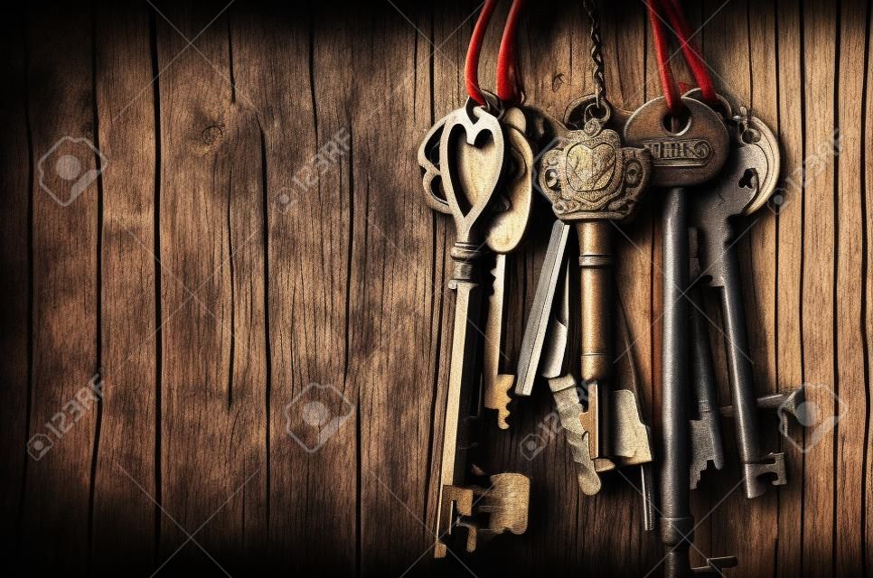 старинные ключ висит на деревянном фоне стены