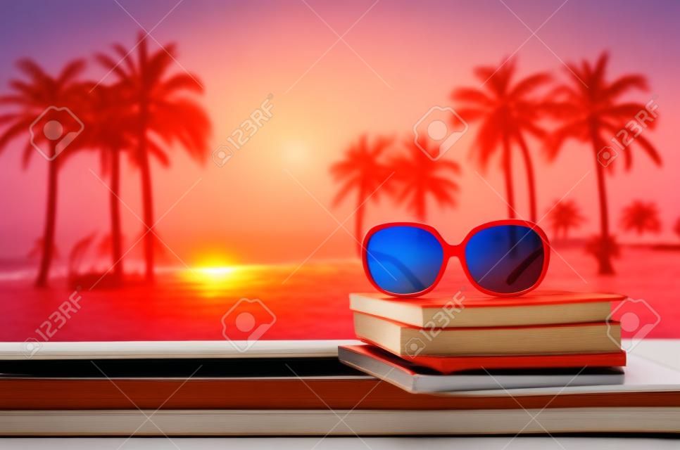 rode zonnebril op stapel boek met zeescape backgroud