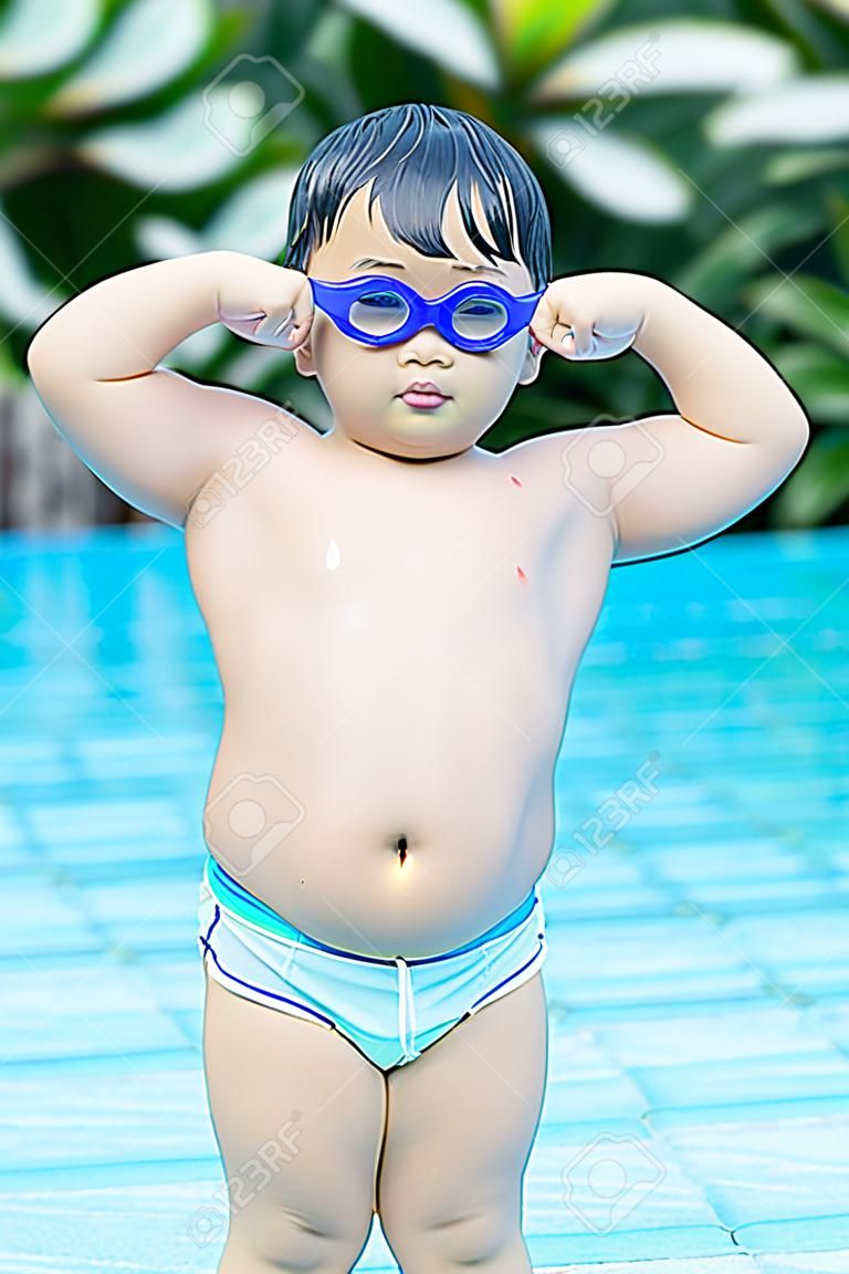chico gordo asiático mostrándole muscular en la piscina.