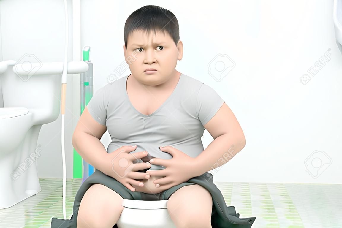 ragazzo grasso soffre di stomaco e si siede in bagno, costipazione diarrea e concetto di salute.