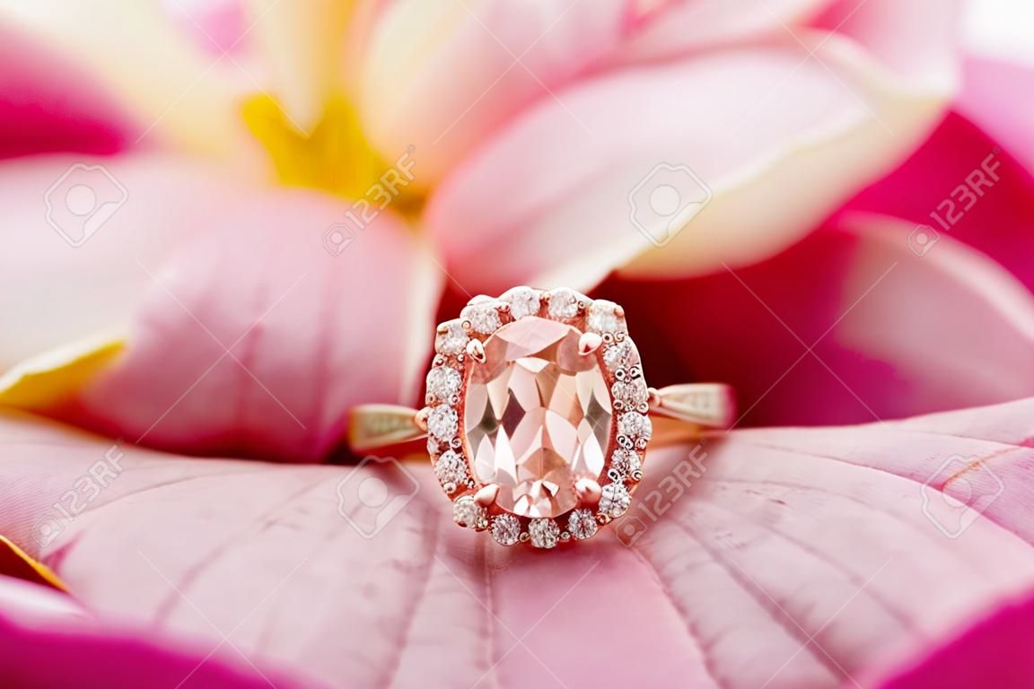 Jewelry pink diamond ring on beautiful rose petal background close up