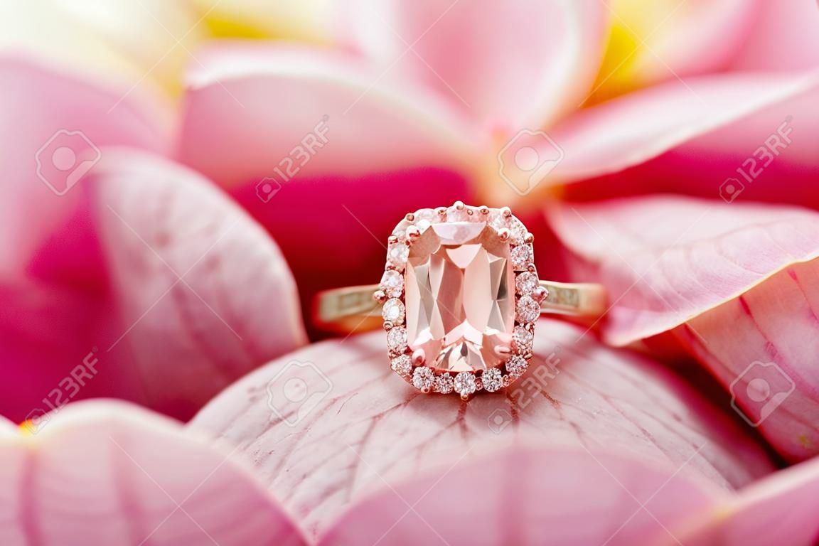 Schmuck rosa Diamantring auf schönem Rosenblütenhintergrund hautnah
