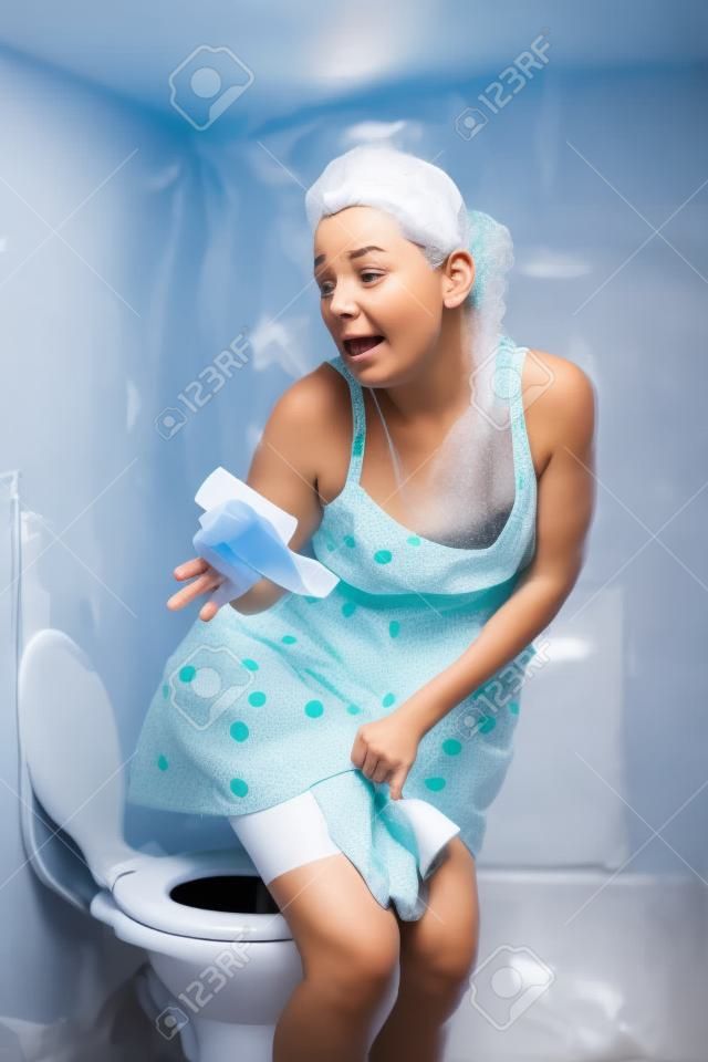 Mujer que hace pis en el inodoro en mal estado y no de papel baño