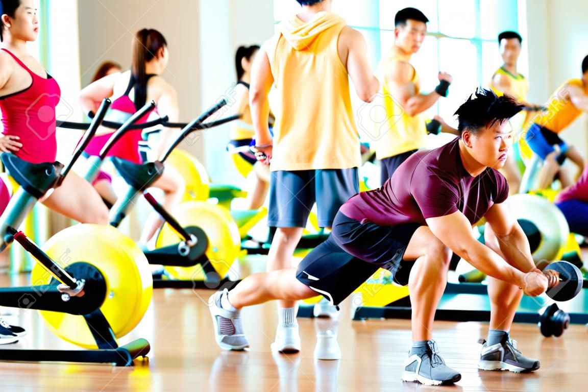 Chinesische asiatische Gruppe von Männern und Frau macht Sport Übungen oder Schulungen in Fitness-Studio mit Hantel Gewichte für mehr Leistung