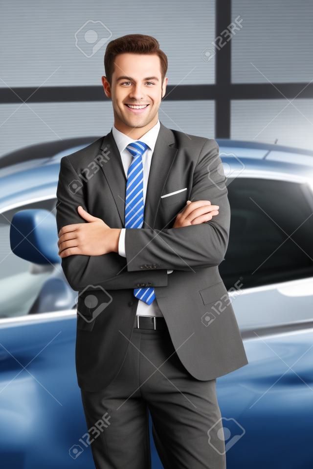 Seller or car salesman in car dealership presenting his new and used cars in the showroom