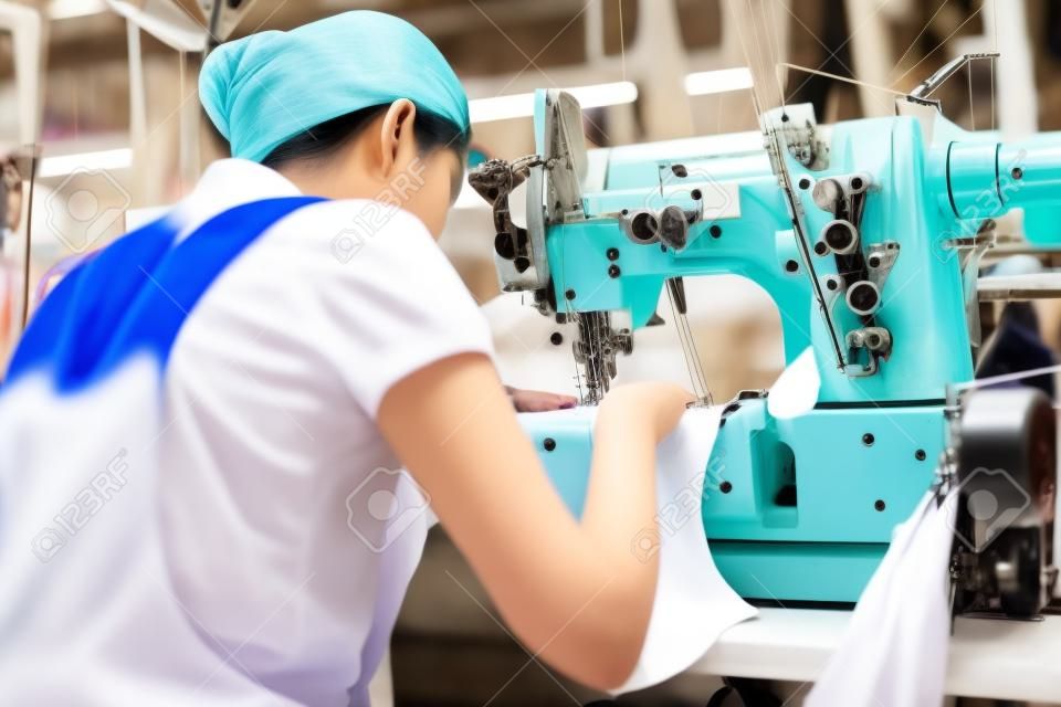 Aziatische naaister of werkster in een Aziatische textiel fabriek naaien met een industriële naaister, ze is zeer nauwkeurig