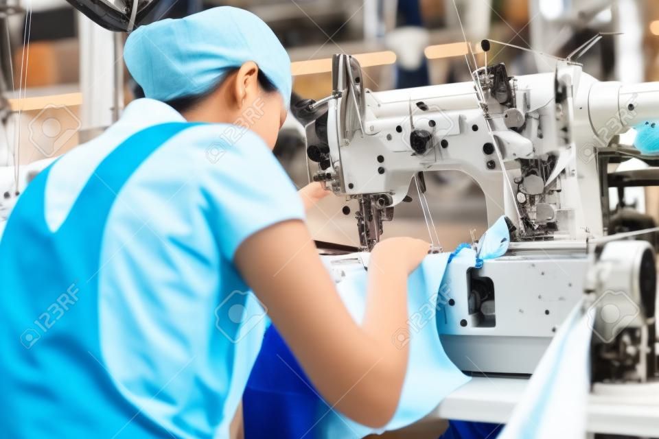 Aziatische naaister of werkster in een Aziatische textiel fabriek naaien met een industriële naaister, ze is zeer nauwkeurig