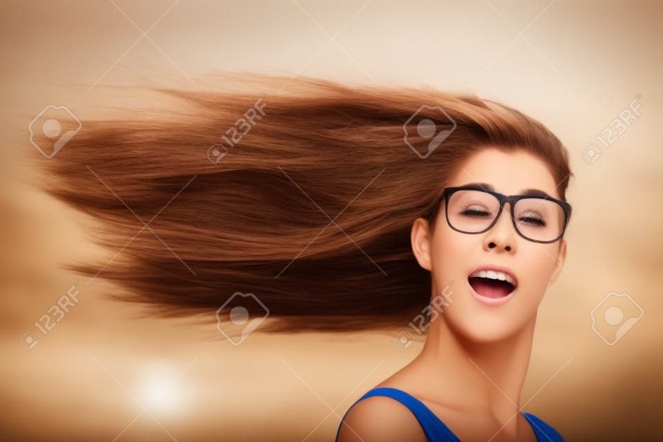 I capelli lunghi della donna che soffia in testa vento