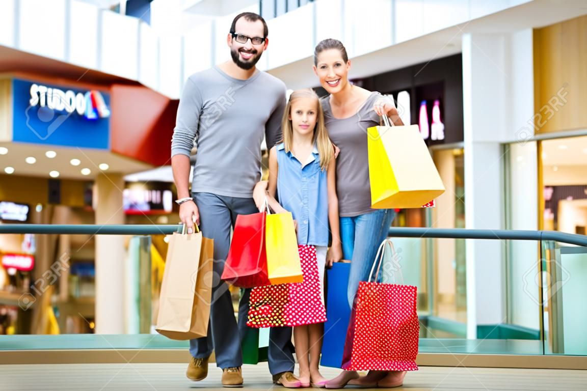 Family of four in shopping mall with bags