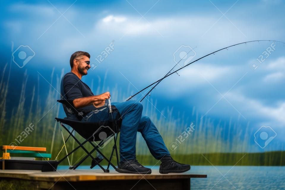 捕魚人在湖邊坐在碼頭靠近水邊