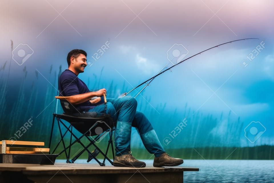 捕魚人在湖邊坐在碼頭靠近水邊