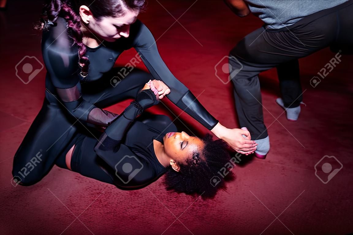 femme combattant frapper son adversaire sur le sol pendant la bataille de mma par une attitude difficile