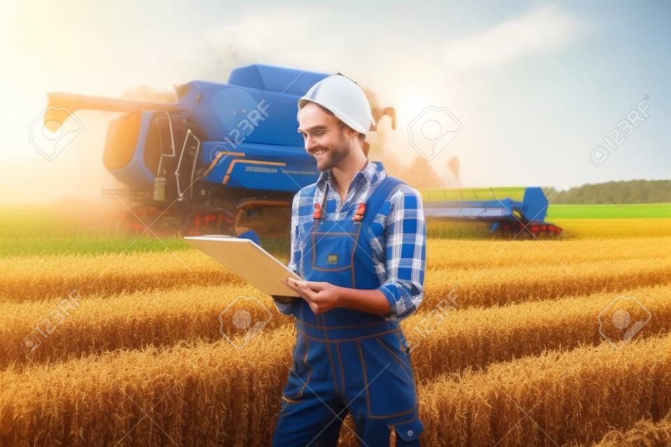 Farmer on a field during harvest with clipboard doing controlling
