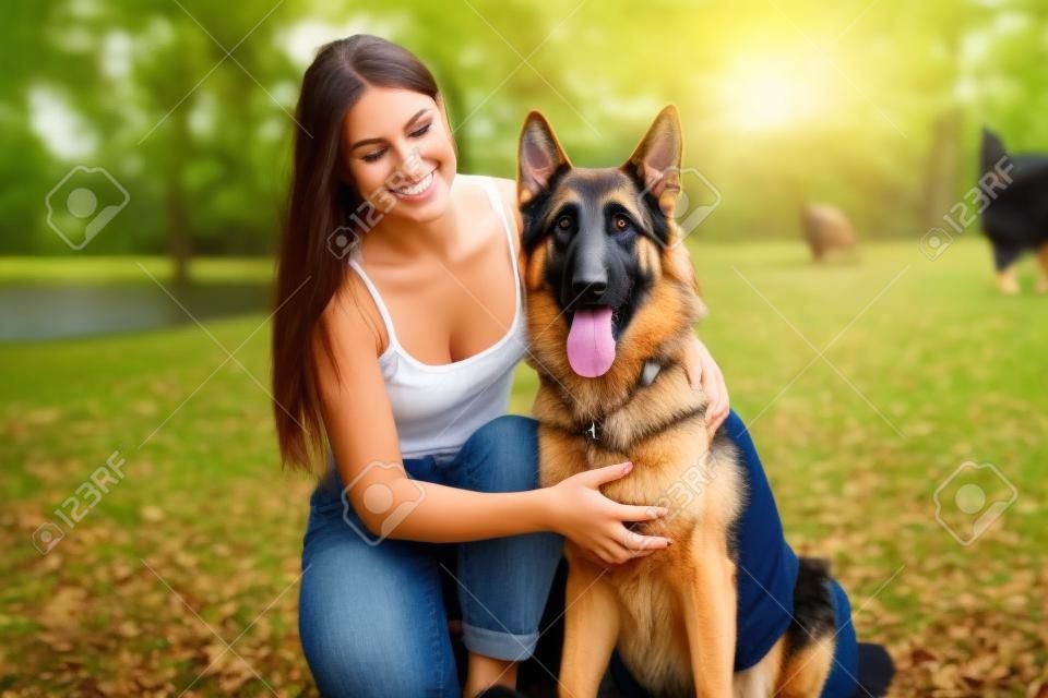 Mädchen mit einem Hund im Park . Deutscher Schäferhund mit einer Frau in der Natur