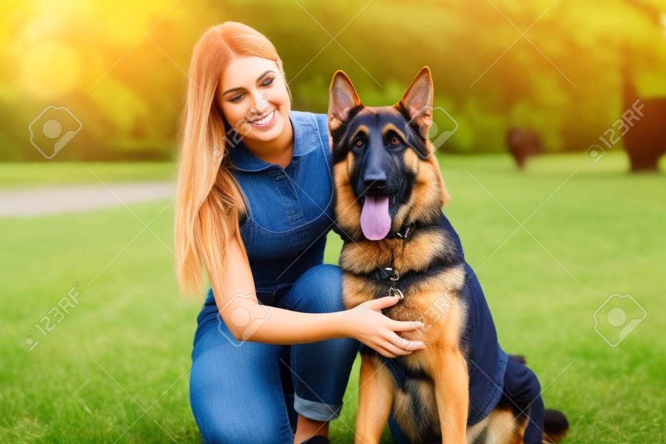 Mädchen mit einem Hund im Park . Deutscher Schäferhund mit einer Frau in der Natur