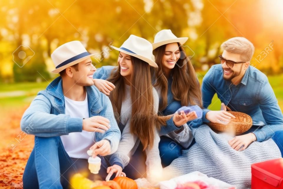 Fröhliche Freunde bei einem Picknick im Park im Frühling im Herbst.