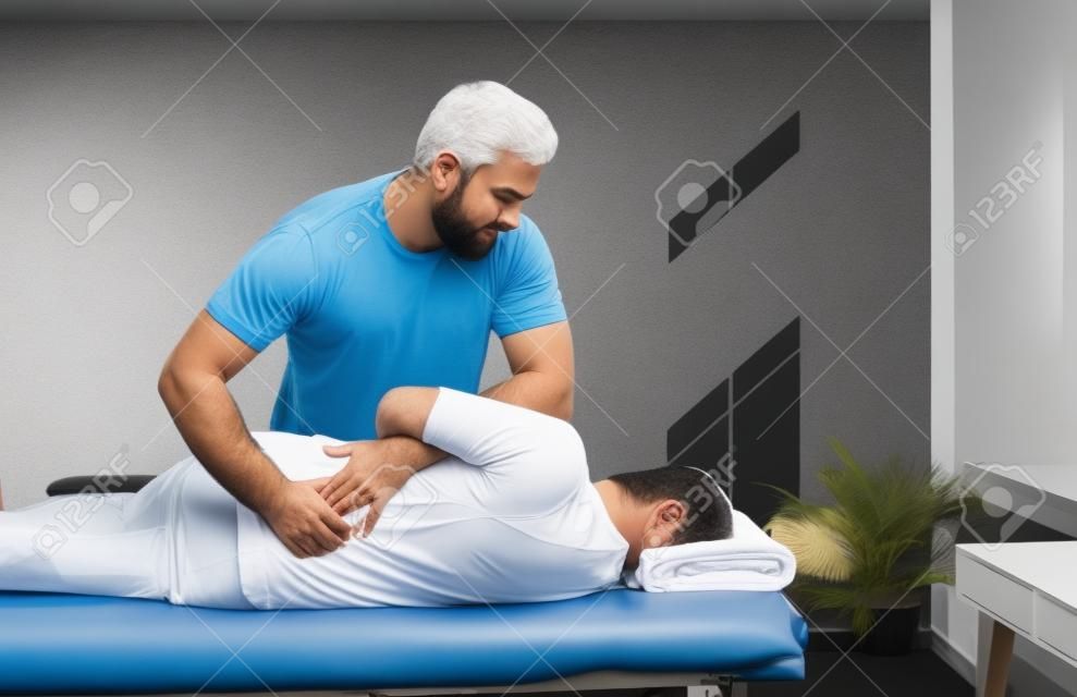 Profesjonalny kręgarz, fizjoterapeuta, osteopata lub terapeuta manualny pracujący z człowiekiem i pomagający wyleczyć problem z plecami. fizjoterapia, rehabilitacja po urazie, koncepcja łagodzenia bólu