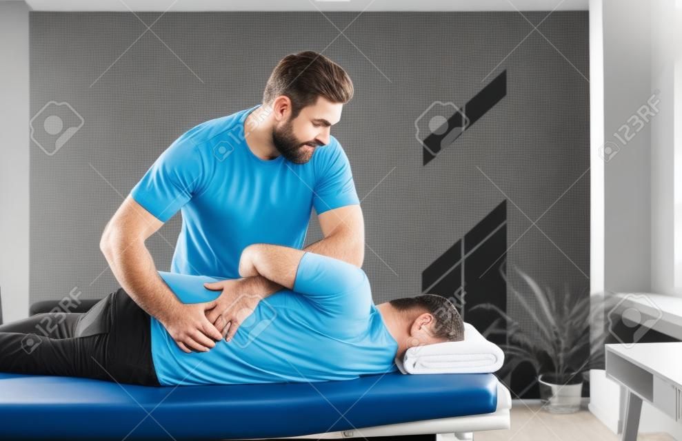 Profesjonalny kręgarz, fizjoterapeuta, osteopata lub terapeuta manualny pracujący z człowiekiem i pomagający wyleczyć problem z plecami. fizjoterapia, rehabilitacja po urazie, koncepcja łagodzenia bólu