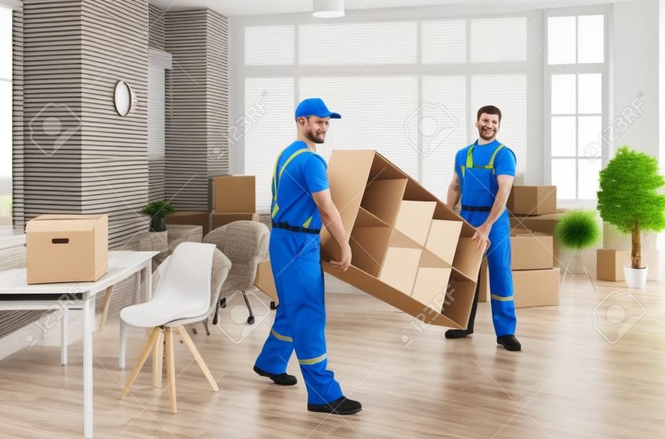 Male movers in uniform carry furniture help client with office or home settle. Deliverymen or carriers work for customer during moving or relocation. Delivery or transportation company service.