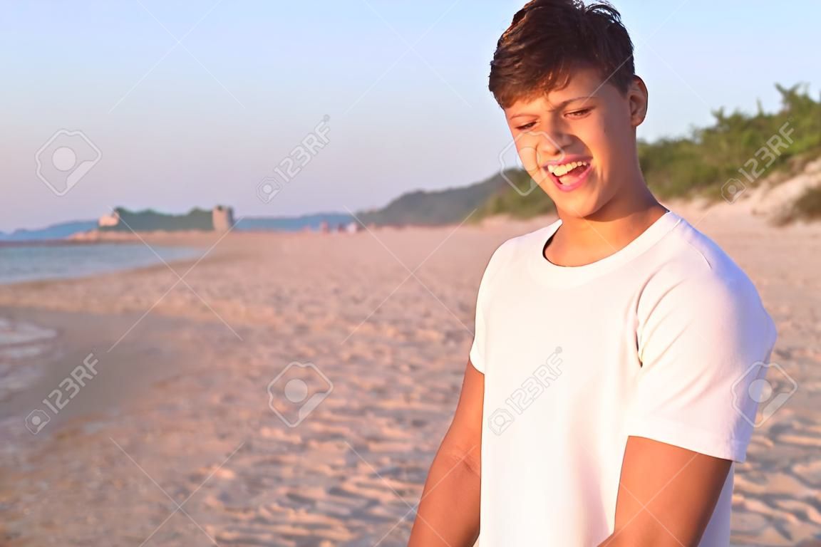 młody człowiek podziwia na plaży, miły młody człowiek jest szczęśliwy na plaży, chłopiec jest bardzo szczęśliwy wypoczynek na morzu