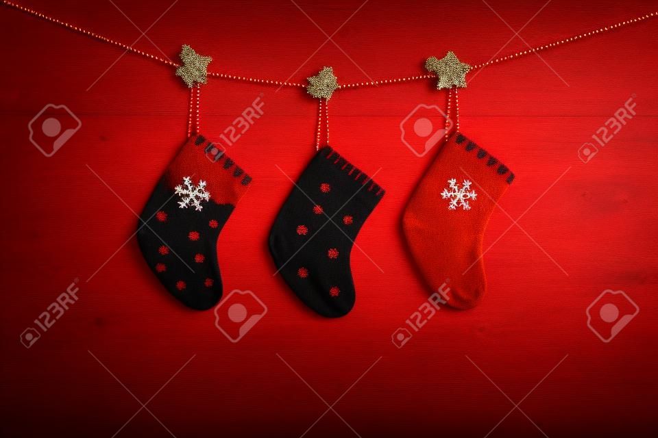 Red Christmas background. Christmas red socks on red wooden background. Copy space