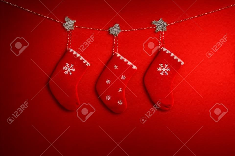 Red Christmas background. Christmas red socks on red wooden background. Copy space