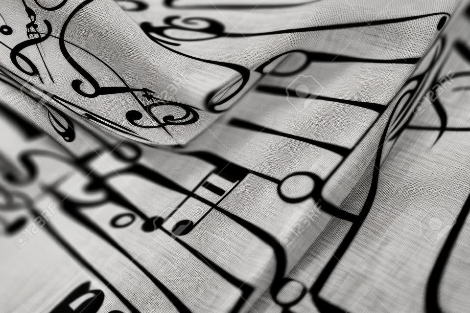 Nappe vintage floue, abstraite, macro imprimée de symboles musicaux. Notes noires sur fond blanc