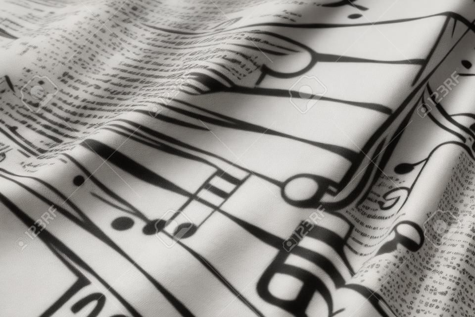 Nappe vintage floue, abstraite, macro imprimée de symboles musicaux. Notes noires sur fond blanc
