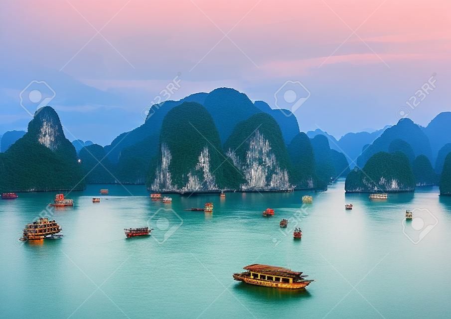 Turisztikai dzsunkák úszó között mészkő kora reggel a Ha Long Bay, Dél-kínai-tenger, Vietnam, Délkelet-Ázsiában. Két kép panoráma