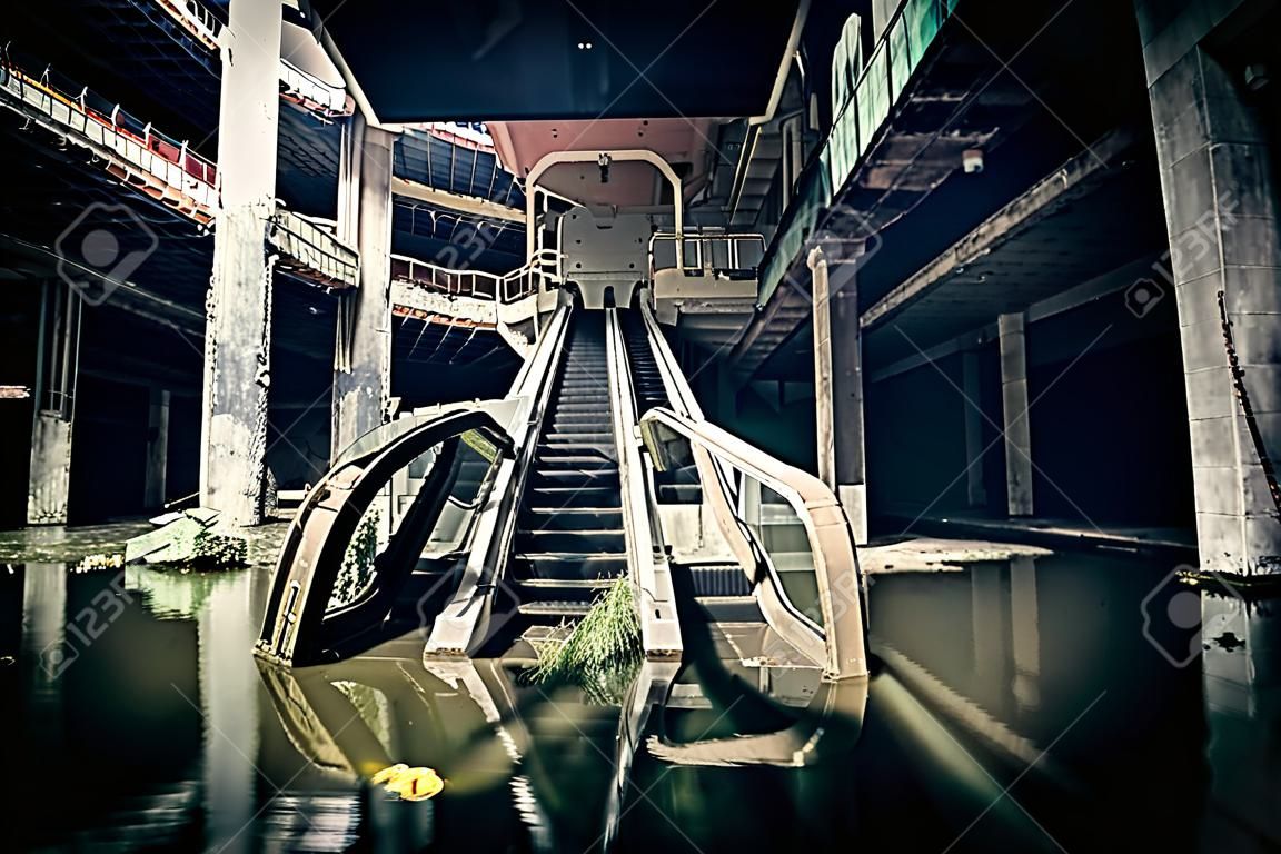 La extraordinaria vista de las escaleras mecánicas dañadas en el centro comercial abandonado hundida por las aguas de inundación lluvia. concepto apocalíptico y el mal
