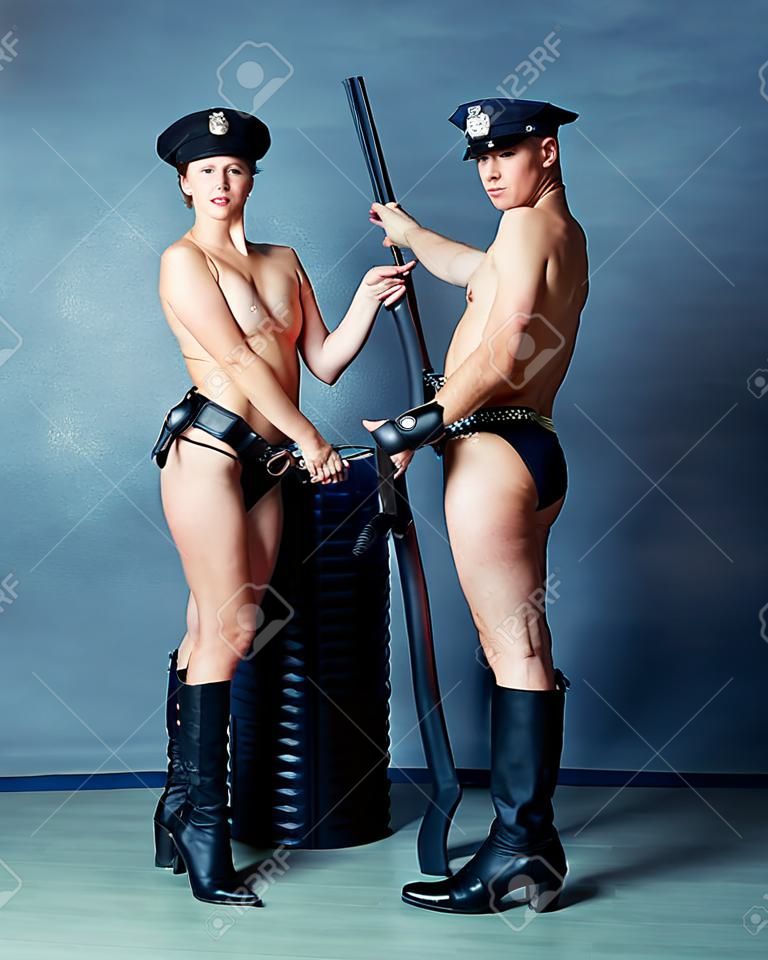 striptease dancers wearing costumes of policemen in the studio