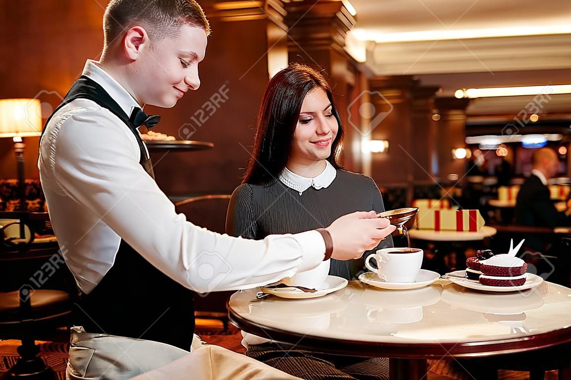 Zet klanten op de eerste plaats. Zelfverzekerde ober serveren desserts en koffie aan klanten. Paar het ontbijt in het hotel restaurant
