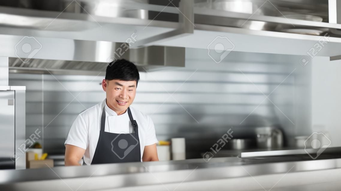 Aziatische man die in de keuken werkt
