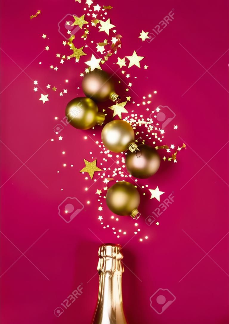 고급스러운 크리스마스 구성에는 금색 샴페인 병과 평평한 평신도 스타일의 세련된 마젠타색 배경 장식이 있습니다. 크리스마스 또는 새해 전야 축하 개념. 휴일 카드.