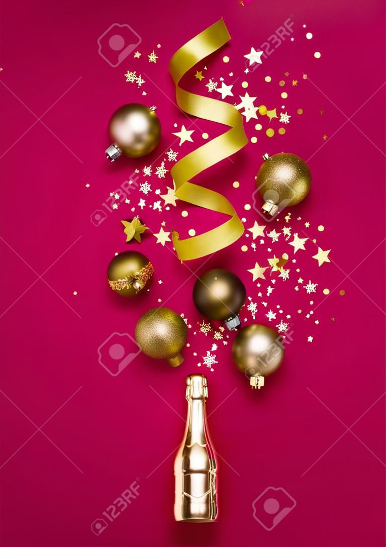 고급스러운 크리스마스 구성에는 금색 샴페인 병과 평평한 평신도 스타일의 세련된 마젠타색 배경 장식이 있습니다. 크리스마스 또는 새해 전야 축하 개념. 휴일 카드.