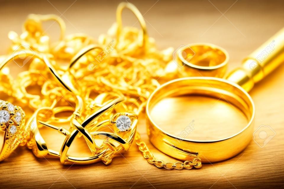 jewelry, pawn shop and buy and sell golden rings, necklace bracelet o wooden background, closeup