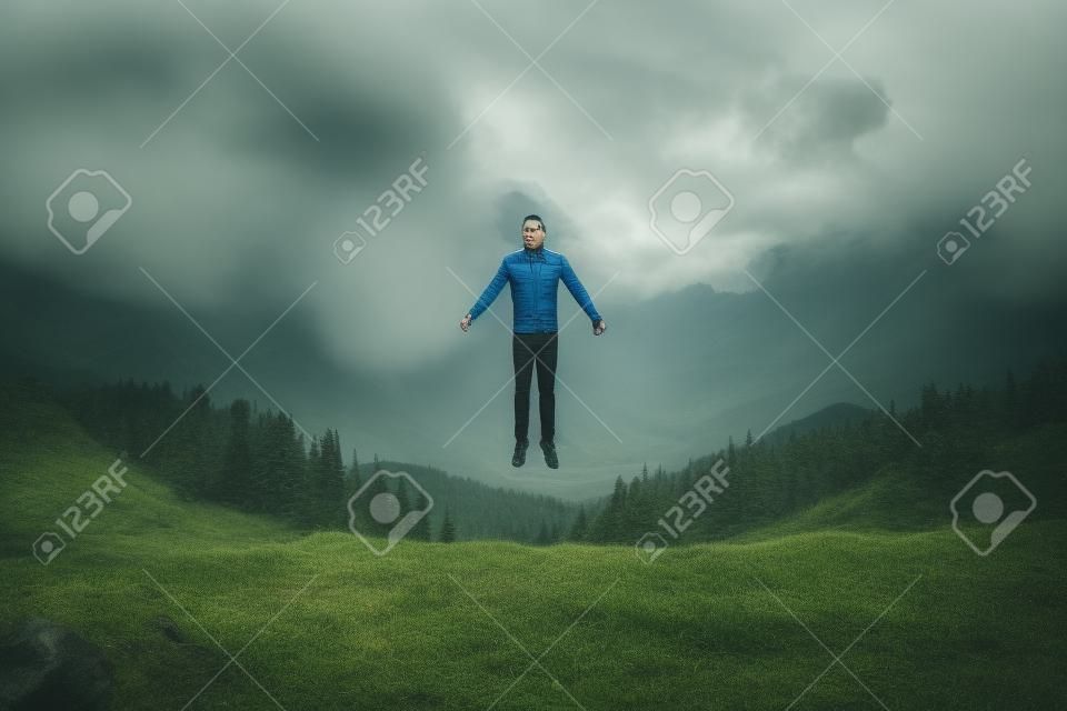 mężczyzna lewitujący przed wzgórzami