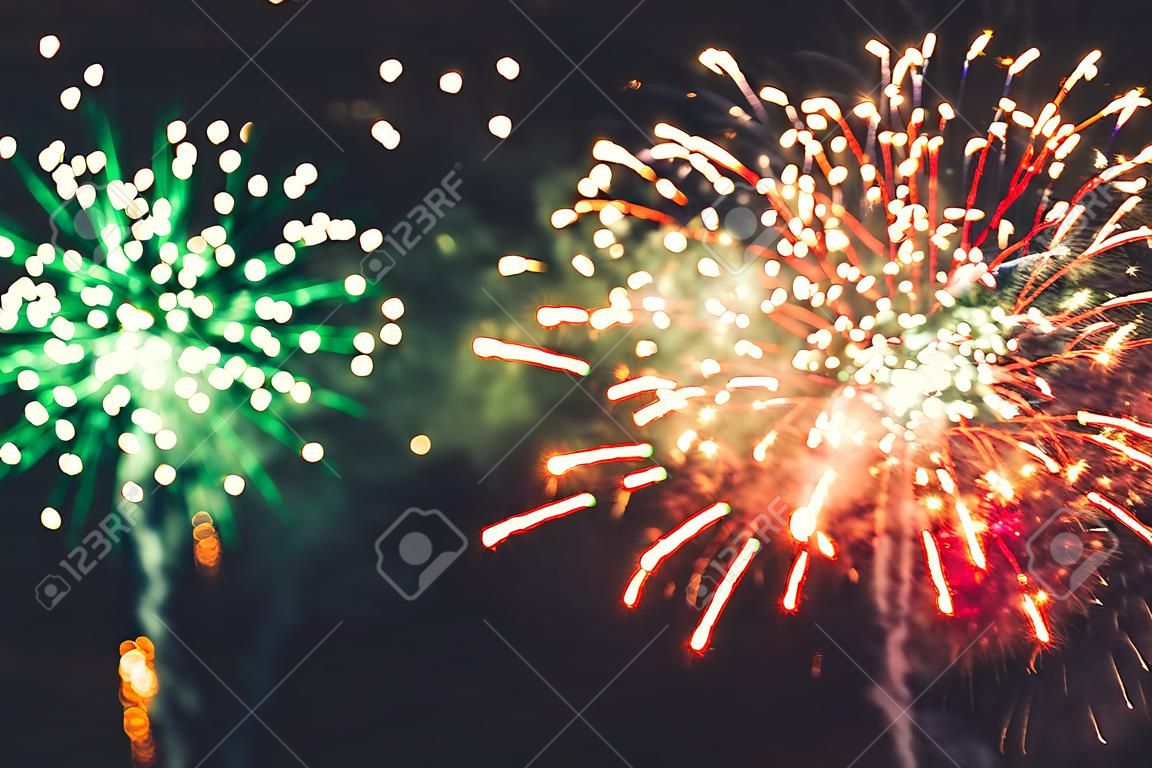 Fuochi d'artificio a Capodanno e copia spazio astratto sfondo vacanza. Fuochi d'artificio dai colori vivaci su sfondo crepuscolare con spazio libero per il testo. Nuovo anno