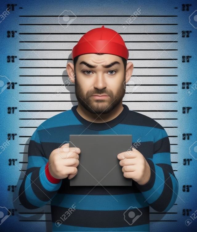 Criminal Foto Gefangen Verbrecher steht neben Wand mit der Nummer in der Hand