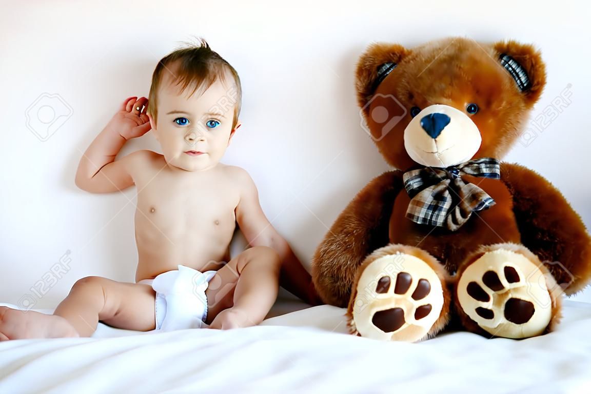 Little Boy sitzt neben a Teddy bear