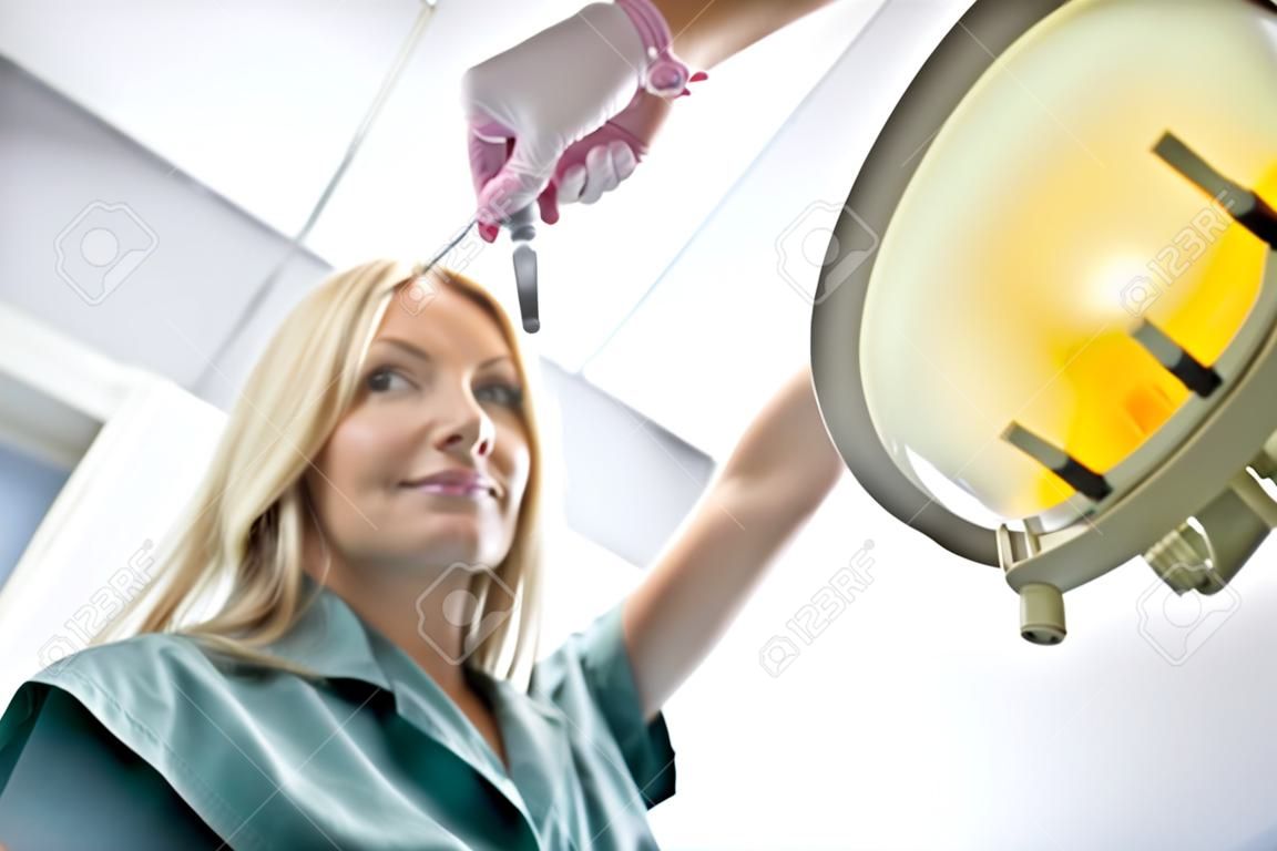 Dentista Femenino Luz de ajuste eléctrico en la Clínica